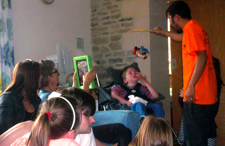 Photograph of a storytelling session at a children's hospice with family members looking on